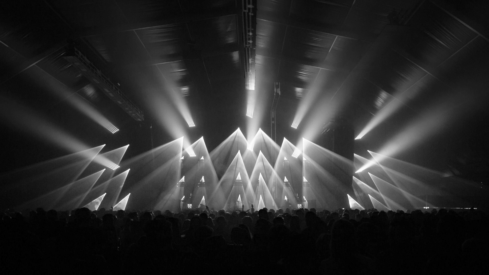 A crowd in front of a lit stage