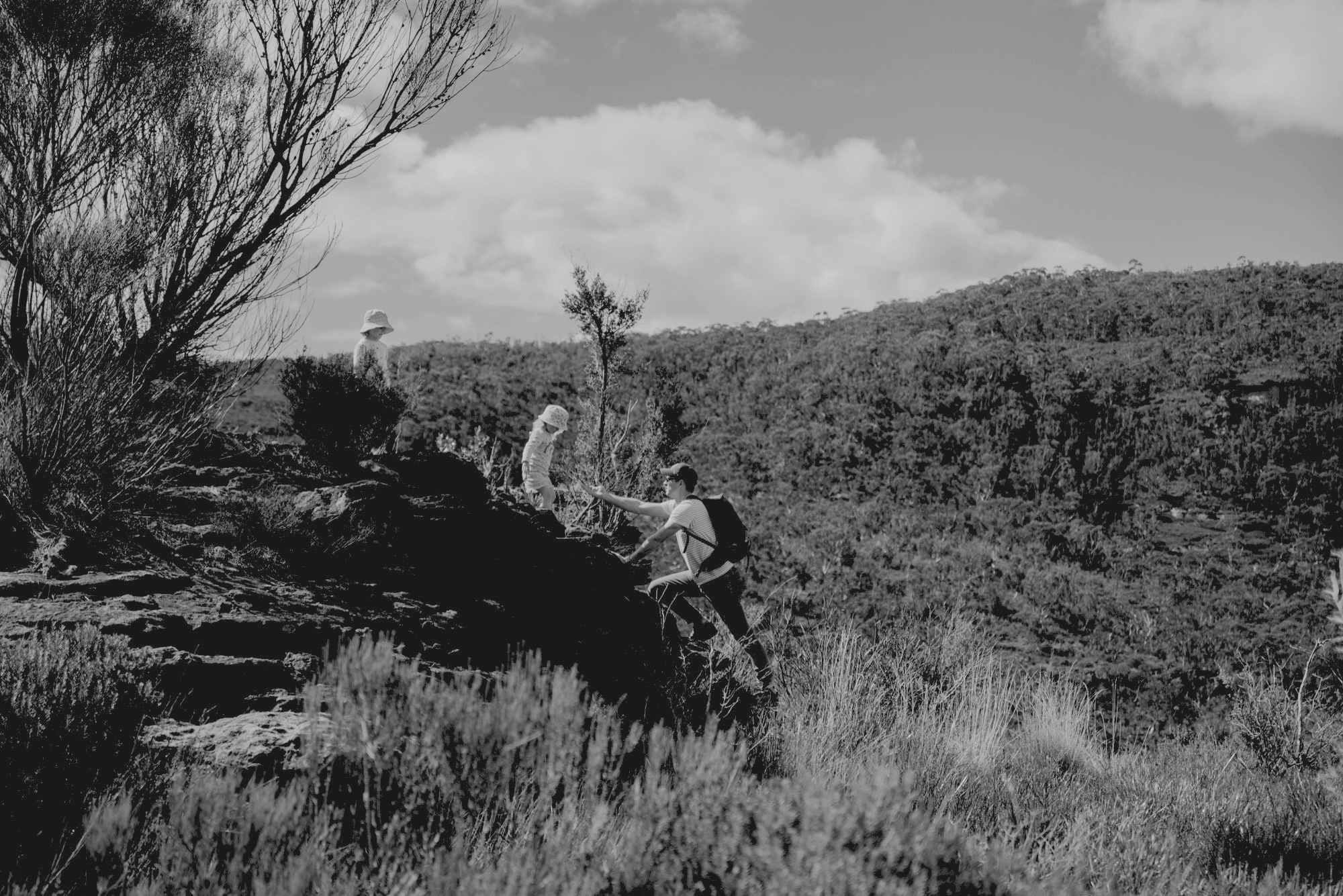 Matt and family on a rocky outcrop above bushland