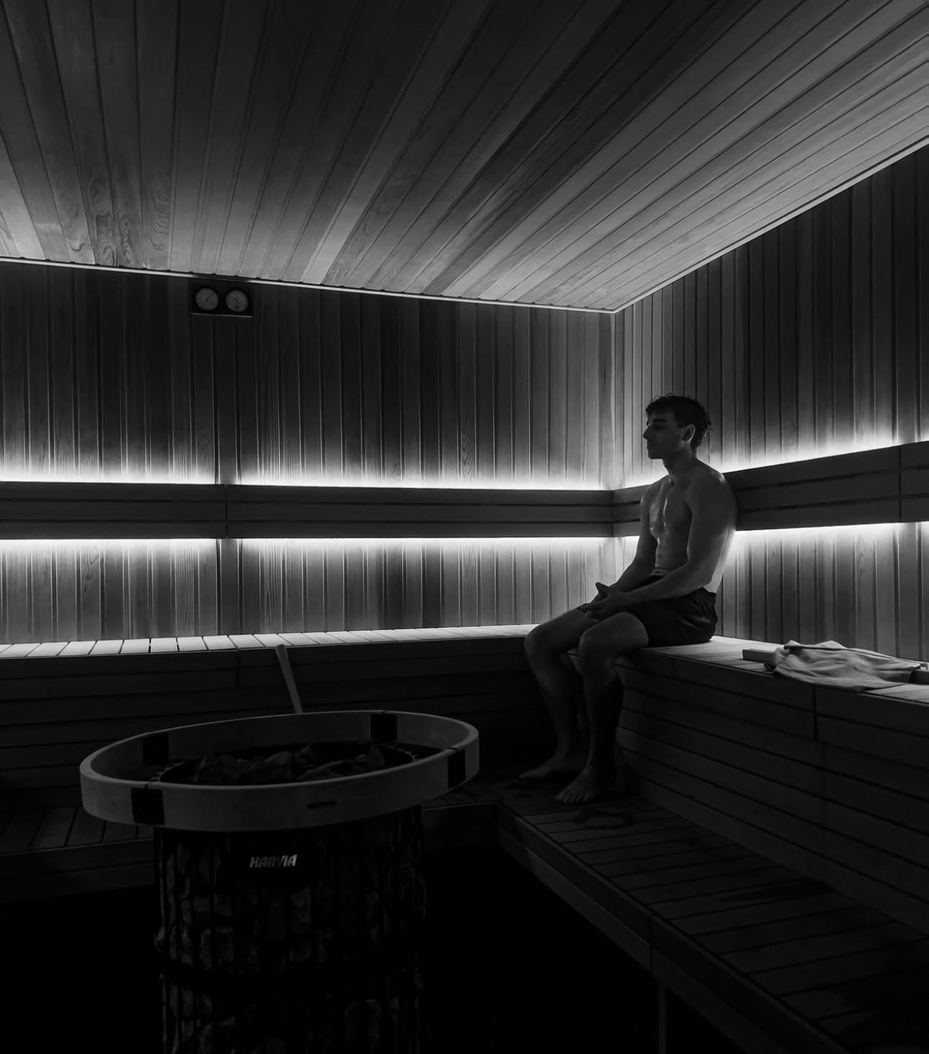 Inside the sauna at Unwind Studios, one person sitting on the top bench